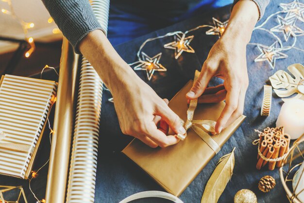 Man making bow from ribbon on gift