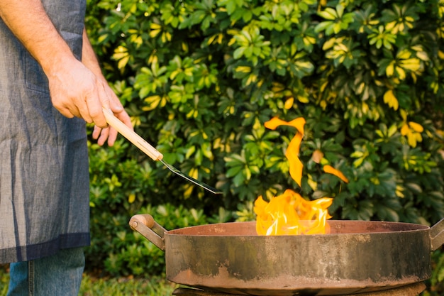 Free Photo man making fire in grill in yard