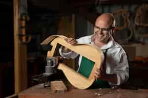 Free photo man making instruments in his workshop