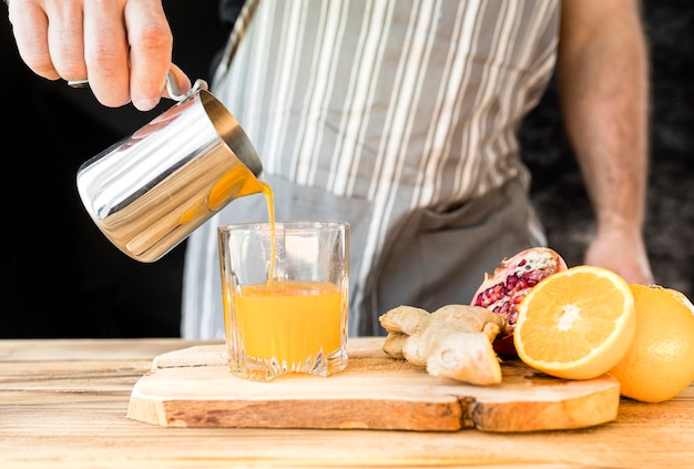 Free photo man making an orange juice front view