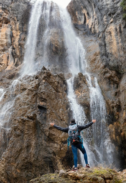 Free photo man in nature at waterfall