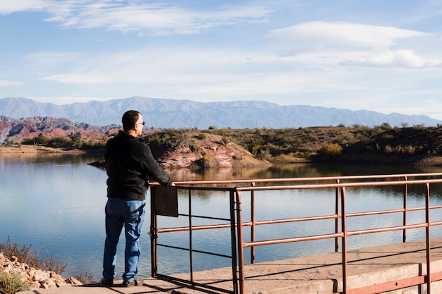 Free photo man near the lake enjoying the sunlight