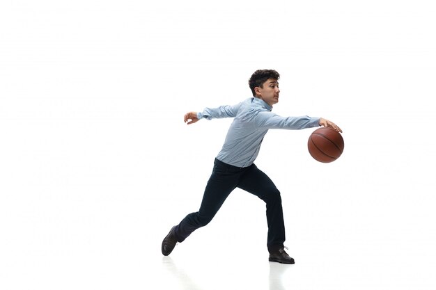 Man in office clothes playing basketball on white space. Unusual look for businessman in motion, action. Sport, healthy lifestyle.