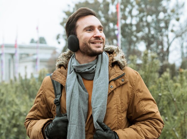 Man outdoors in the winter wearing ear muffs