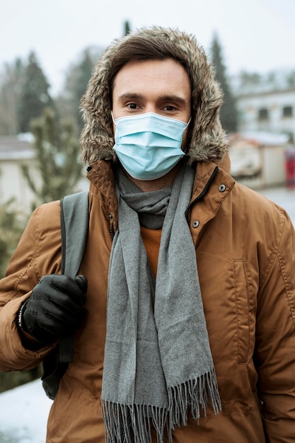 Free Photo man outdoors in the winter wearing medical mask