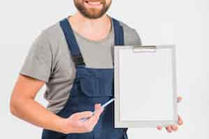 Free photo man in overall showing clipboard with blank paper