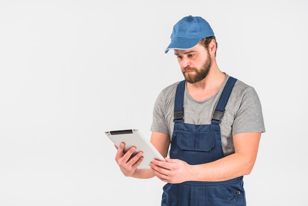 Man in overall using tablet 