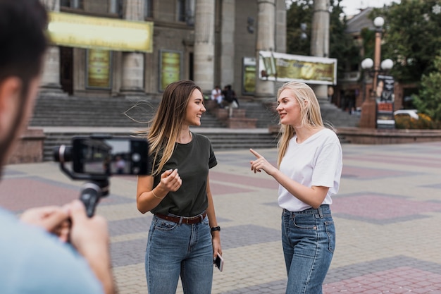 Man photographing beautiful girls with phone