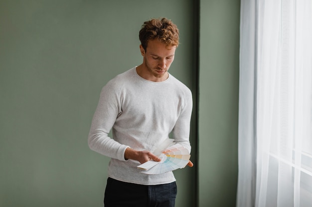 Free Photo man planning to redecorate the house using paint palette