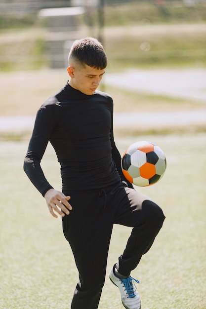 Free photo man play socerl at the park. tournament on mini-footbal. guy in a black sportsuits.