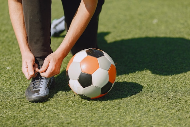 Man play socerl at the park. Tournament on mini-footbal. Guy in a black sportsuits.