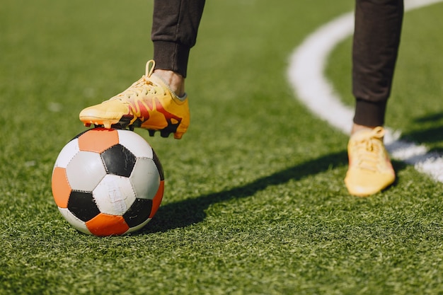 Man play socerl at the park. Tournament on mini-footbal. Guy in a black sportsuits.