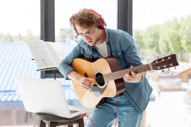 Man playing accoustic guitar in the house