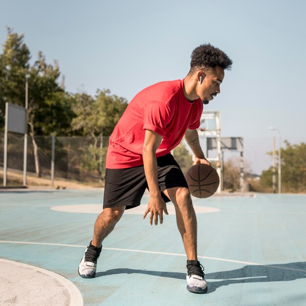 Man playing basketball outside