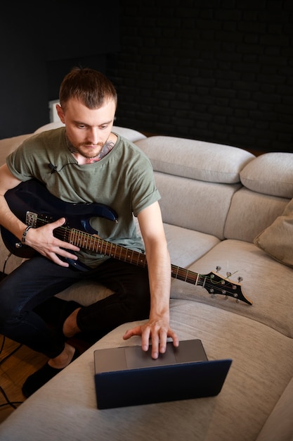 Man playing guitar at home