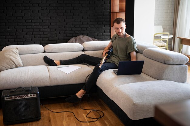 Man playing guitar at home