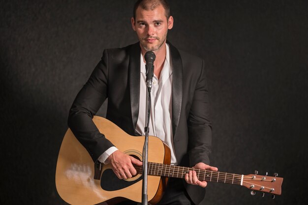 Man playing guitar and singing on microphone