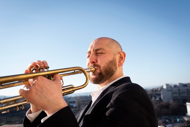 Free photo man playing trumpet jazz day