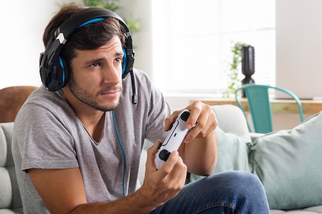 Free photo man playing with controller on couch