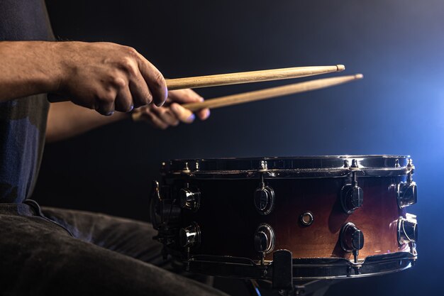 A man plays with sticks on a drum, a drummer plays a percussion instrument, close-up.