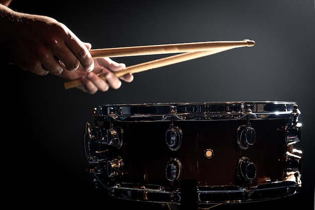 A man plays with sticks on a drum, a drummer plays a percussion instrument, copy space.