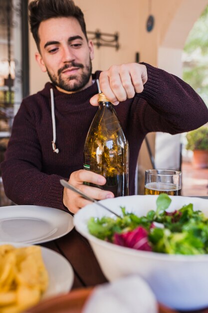 Man plugging bottle of beer on picnic