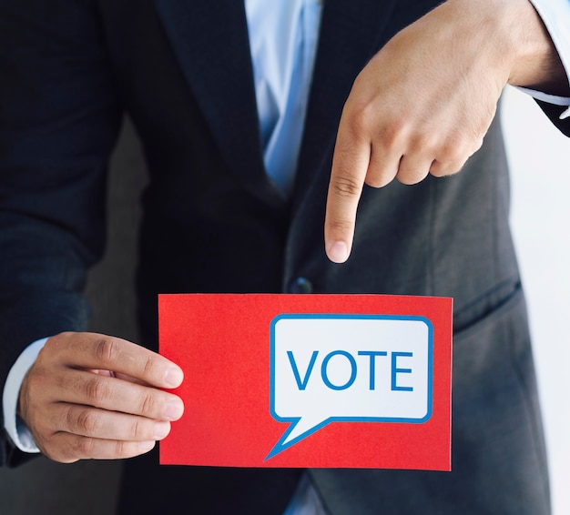 Free photo man pointing to his ballot paper