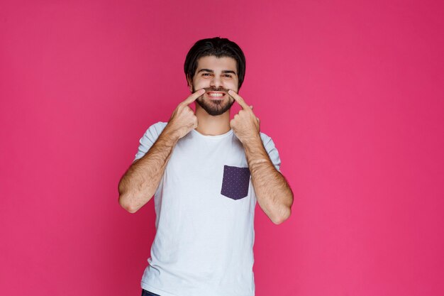 Man pointing his chin and asking to smile. 