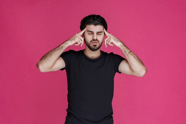 Man pointing his head and overthinking about something trying to remember