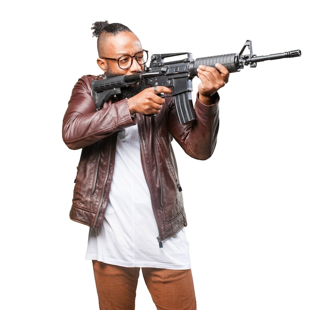 Free photo man pointing to his side with machine gun