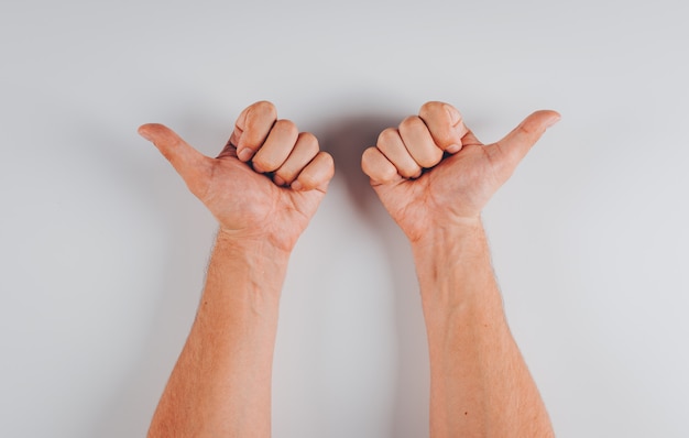 Free photo man pointing opposite directions with his hands top view on white