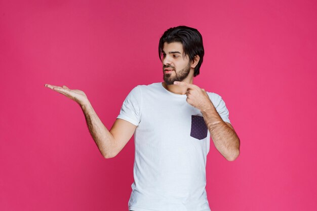 Man pointing at something in his hand. 