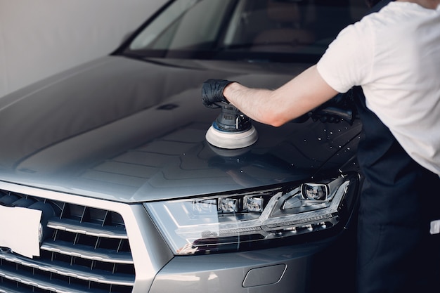 Man polish a car in a garage