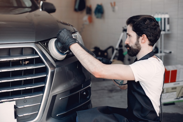 Free photo man polish a car in a garage