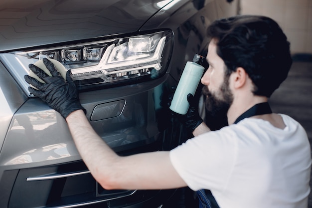 Man polish a car in a garage