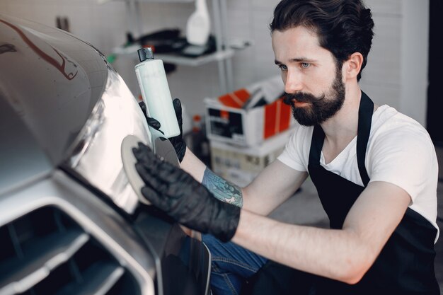 Man polish a car in a garage