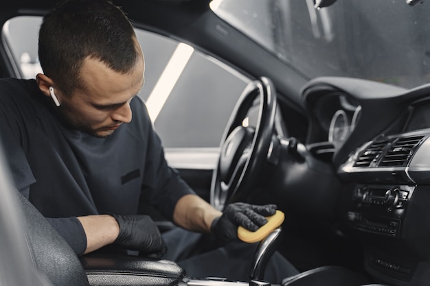 Man polish salon of car in a garage