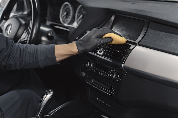 Man polish salon of car in a garage