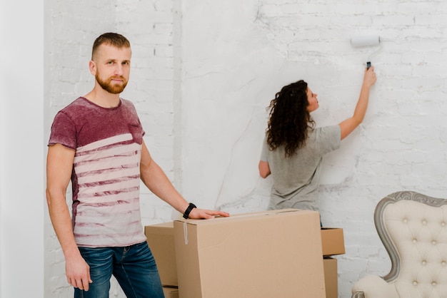 Free photo man posing near woman painting wall