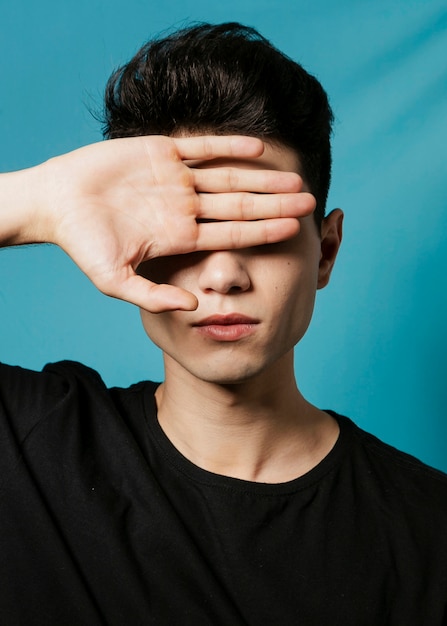 Man posing while holding his hand on eyes