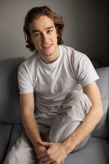 Man posing while smiling on sofa