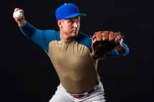 Free photo man posing with baseball glove and ball