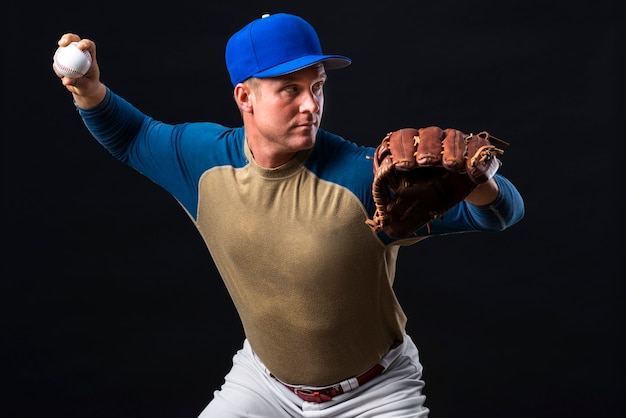 Man posing with baseball glove and ball