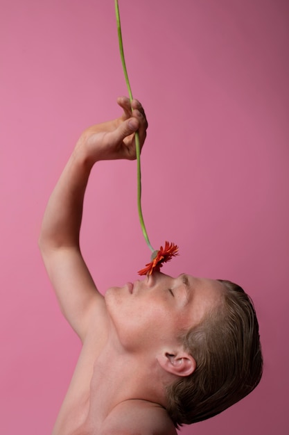 Free photo man posing with red flower side view