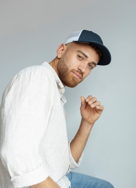 Free photo man posing with trucker hat side view