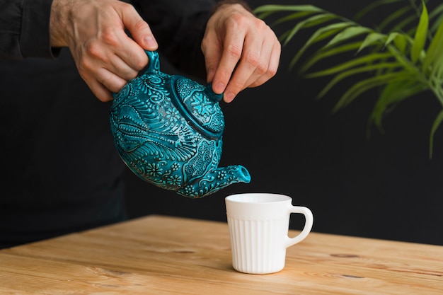 Man pouring tea in mug