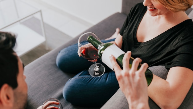 Free Photo man pouring wine to girlfriend on couch