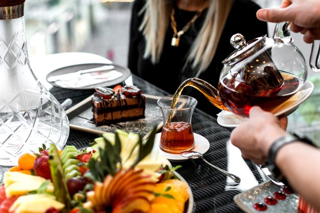 Man pours tea into the armudu glass