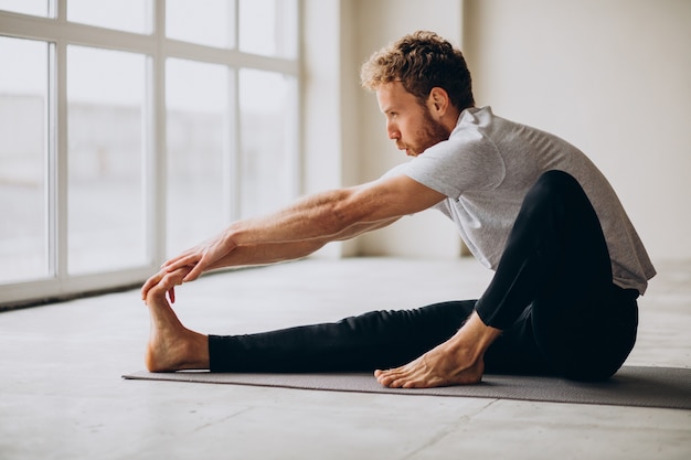 Man practicing yoga on the mat at home