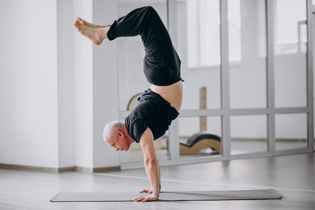 Man practising yoga in the gym